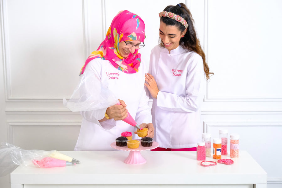 Samia and Mira piping cupcakes in the Yummy Bakes kitchen